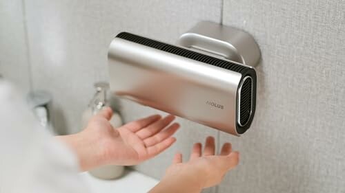 Person using wall-mounted hand dryer