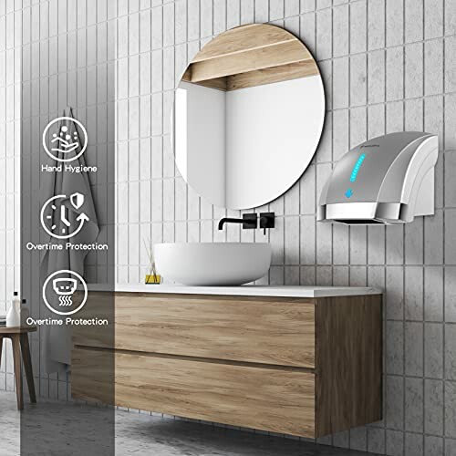 Modern bathroom with round mirror, wooden vanity, and wall-mounted hand dryer.